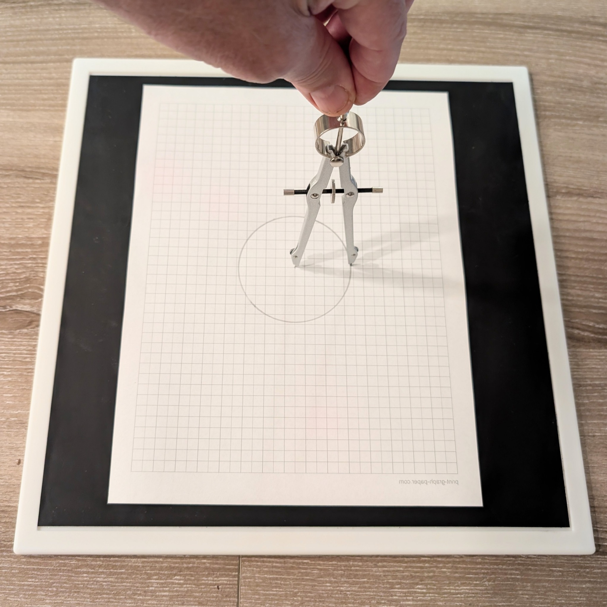 The Perfect Circle platform in use with a drafting compass and graph paper