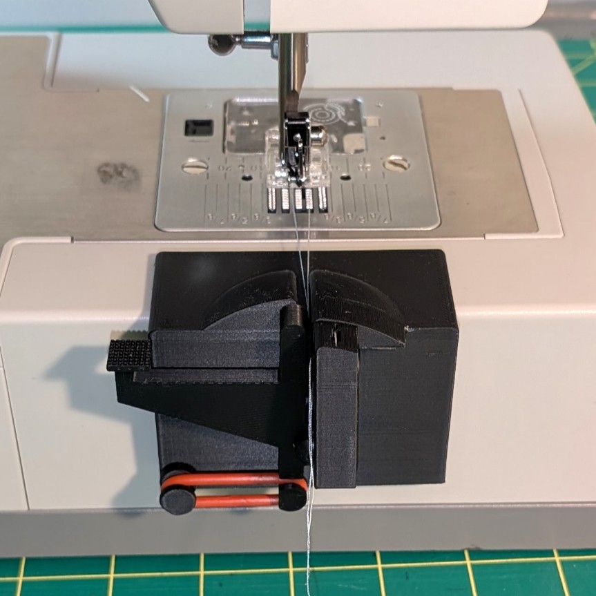Black StitchStart thread clamp mounted beside a sewing machine